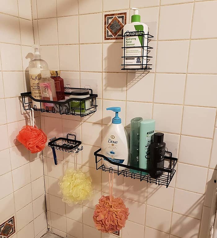 a reviewer photo of the black wire shower organizers attached to a shower wall
