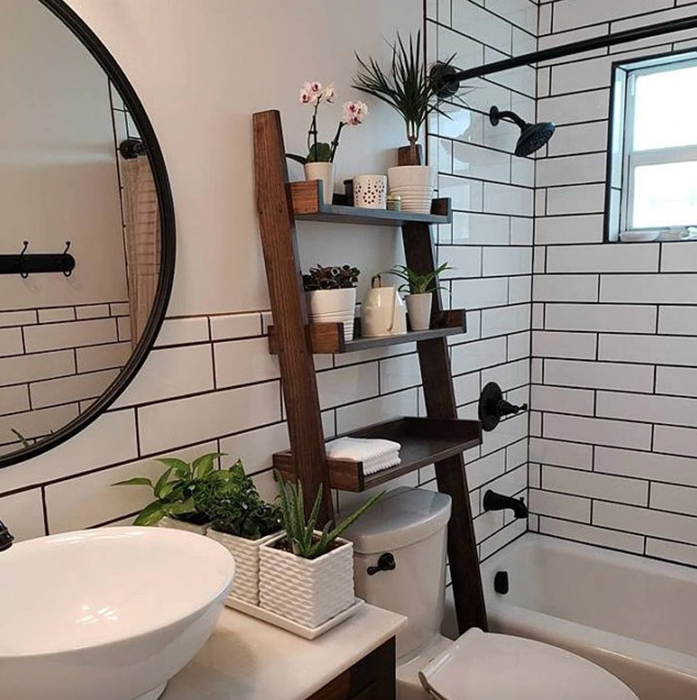 a photo of the dark wood ladder shelf in a decorated white bathroom space