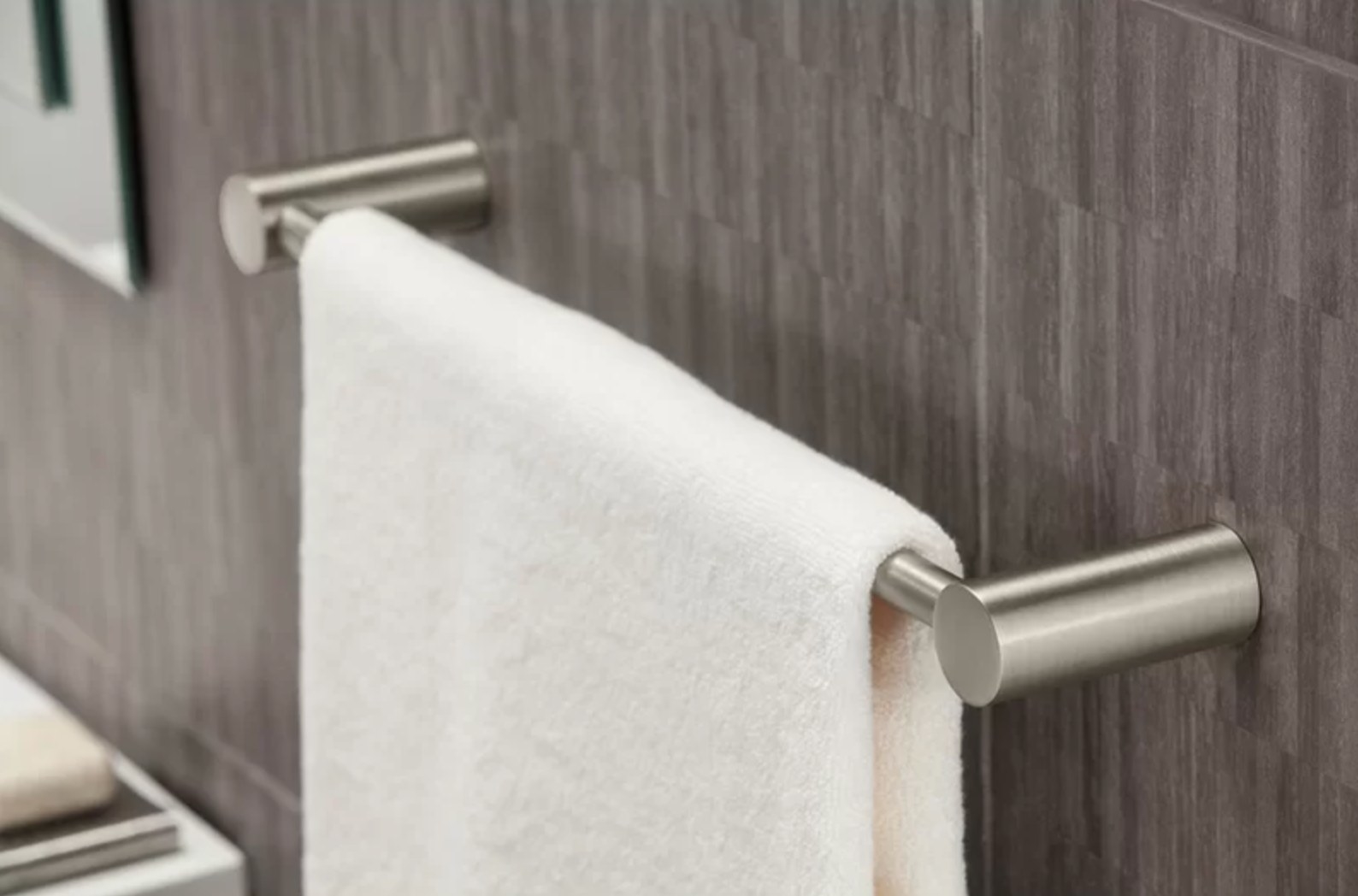 the brushed silver towel rack holding a white towel