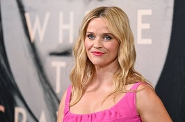 Reese Witherspoon smirks as she poses for a red carpet photo