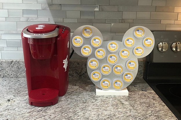 a silver mickey-shaped k-cup holder next to a keurig machine