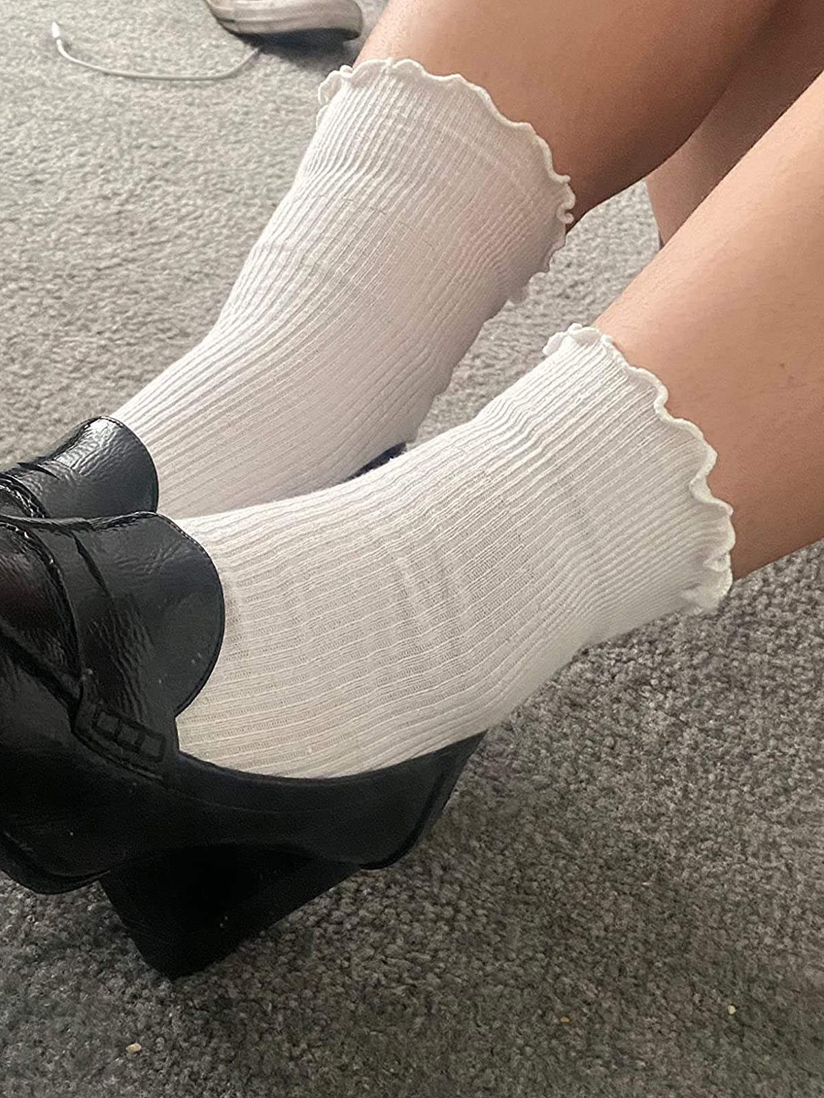 Reviewer wearing white lettuce-edge ankle socks with black shoes