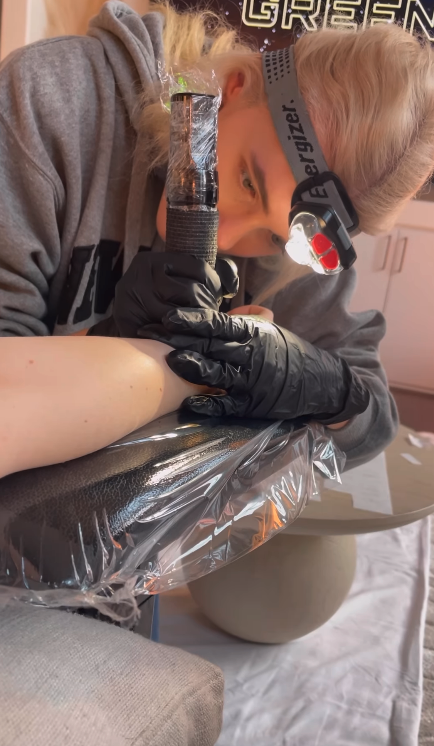 tattoo artist working on taylor&#x27;s arm