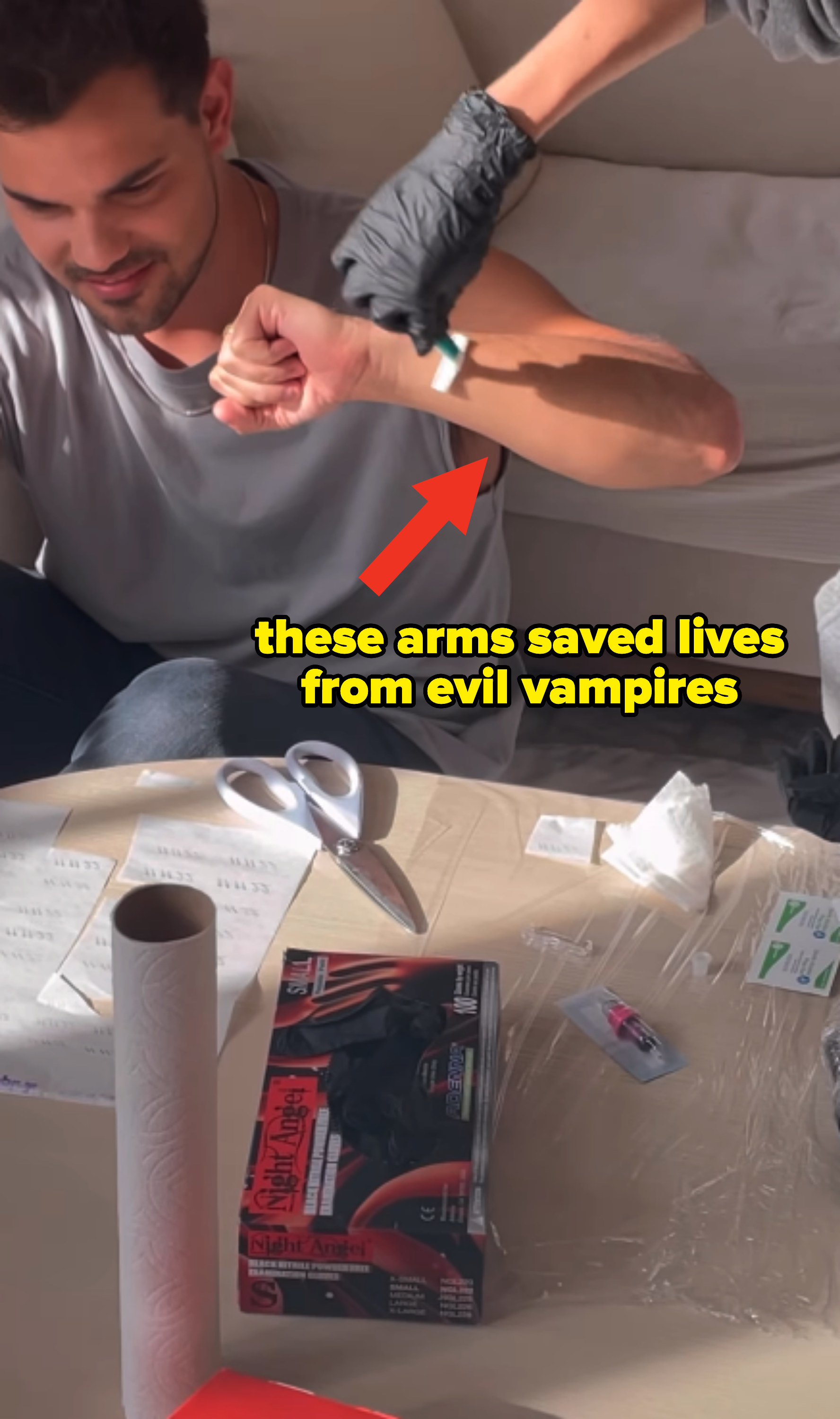 taylor sitting down having his arm prepped with text, these arms saved lives from evil vampires