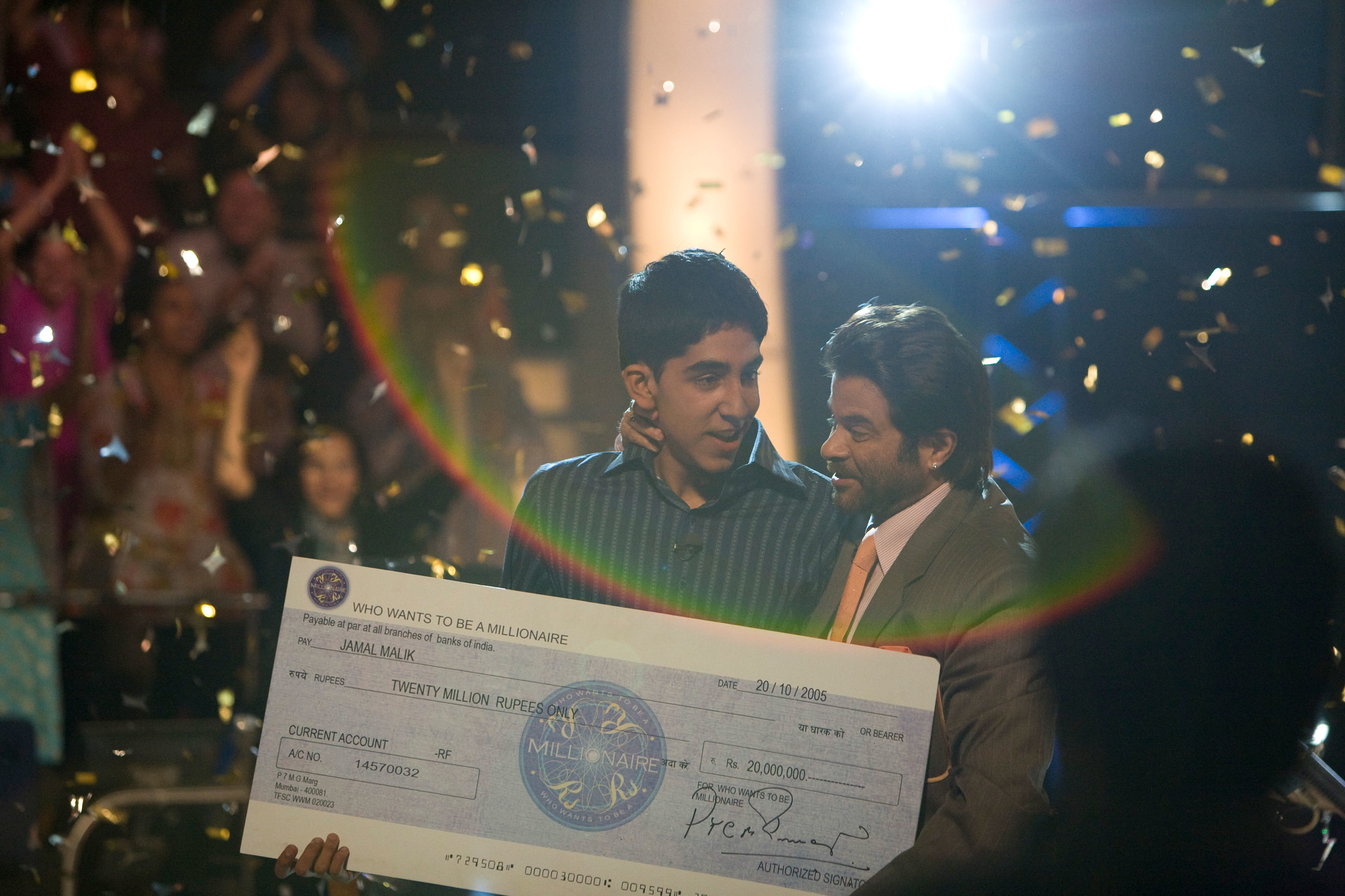 A man holds a check after winning a game show