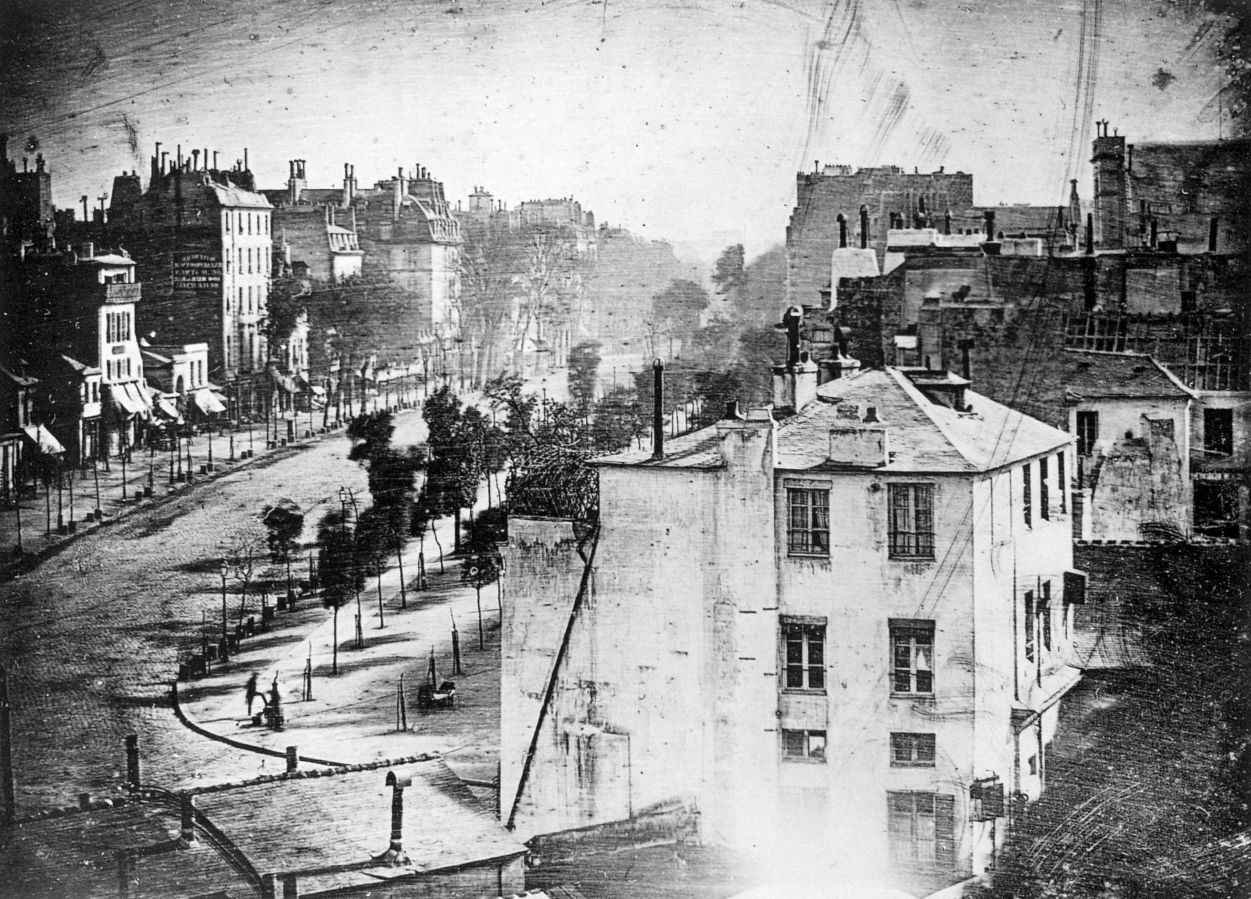 A street scene with at least one people visible, as seen from a higher vantage point