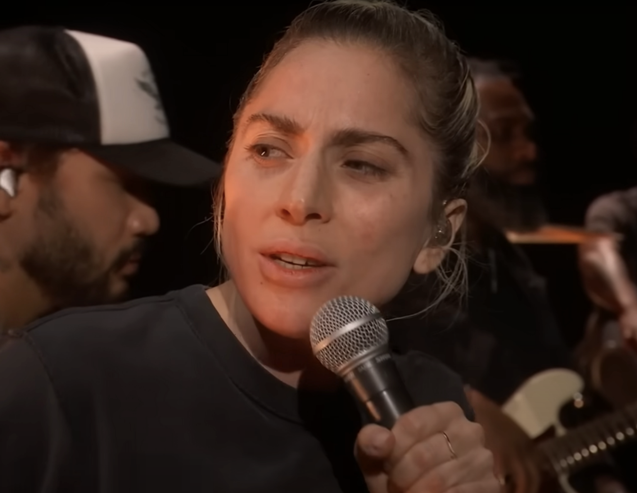 Close-up of make-free Gaga singing into a microphone