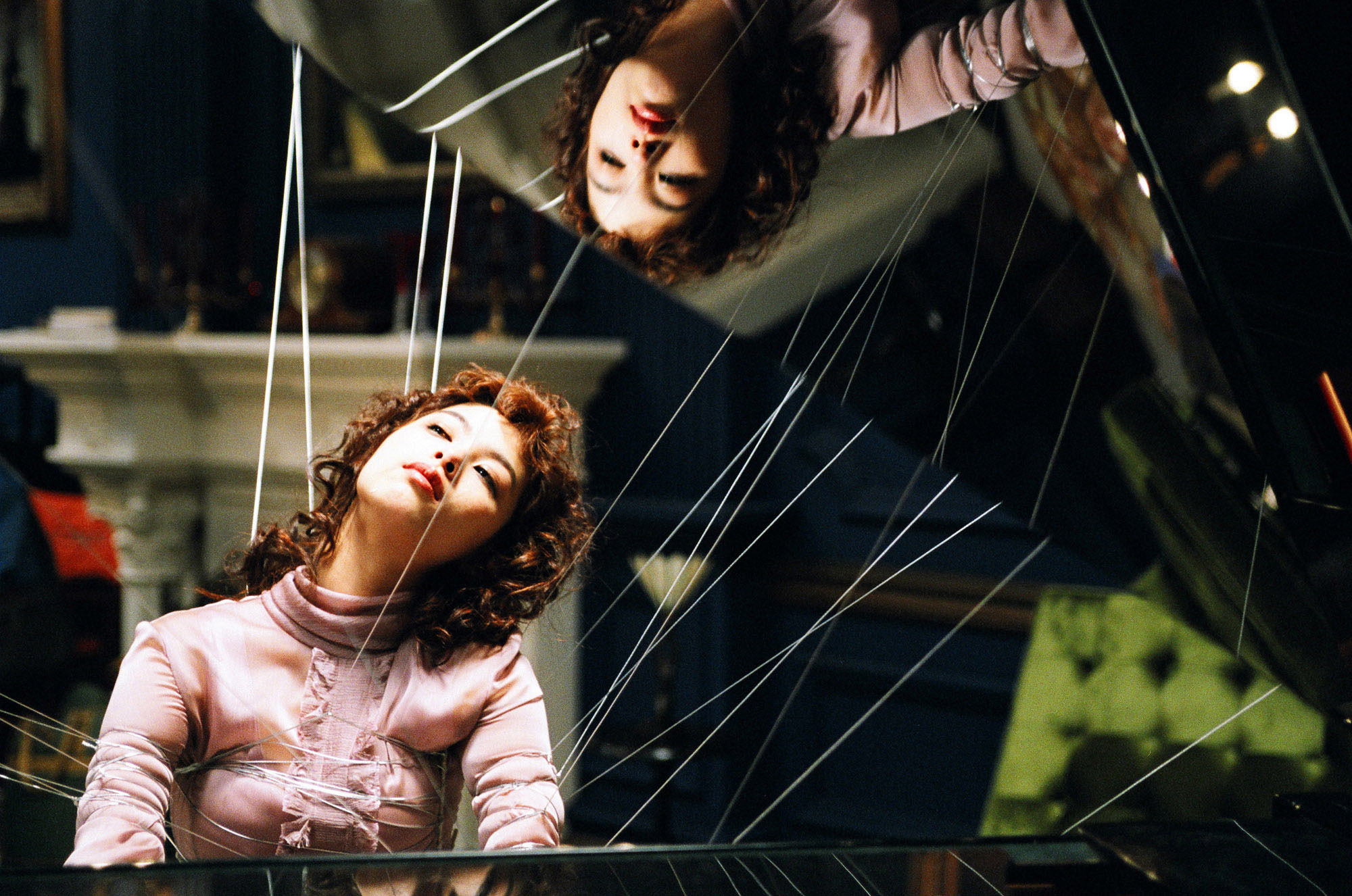 An barely conscious woman is stuck to a pianoand a number of wires