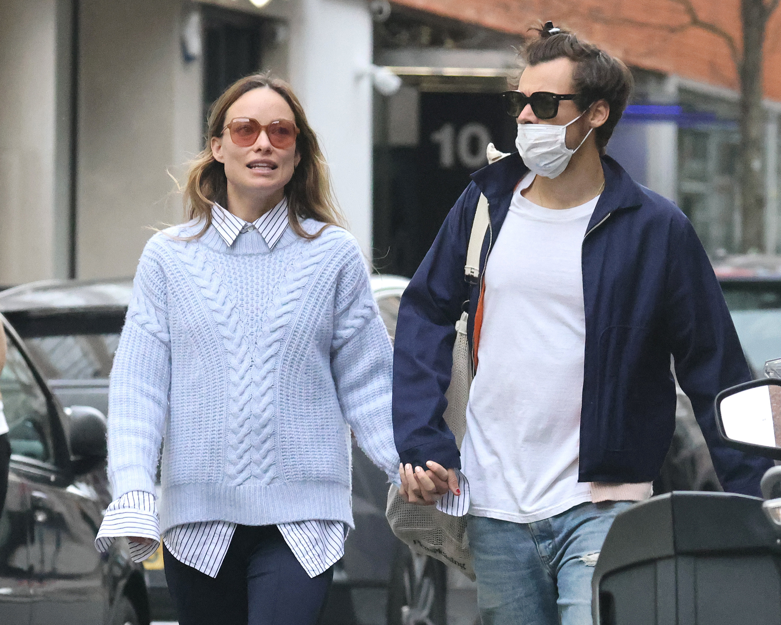 Harry and Olivia hold hands while walking