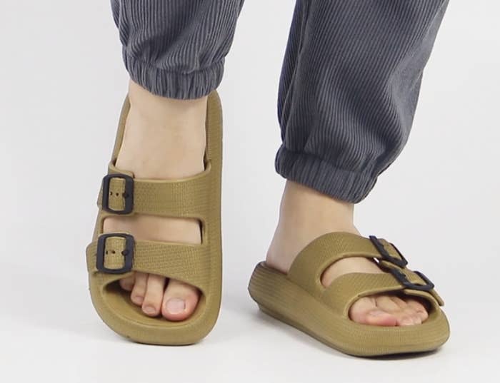 person wearing the slides with their right foot lifted