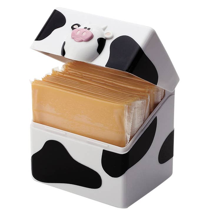 a cow-themed container holding cheese slices on a blank background