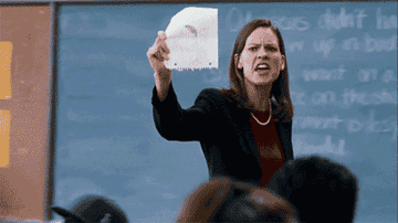 A teacher holding up a piece of paper