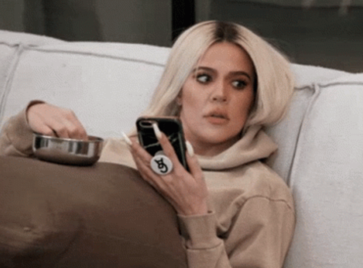 Khloe Kardashian laying in bed on her phone