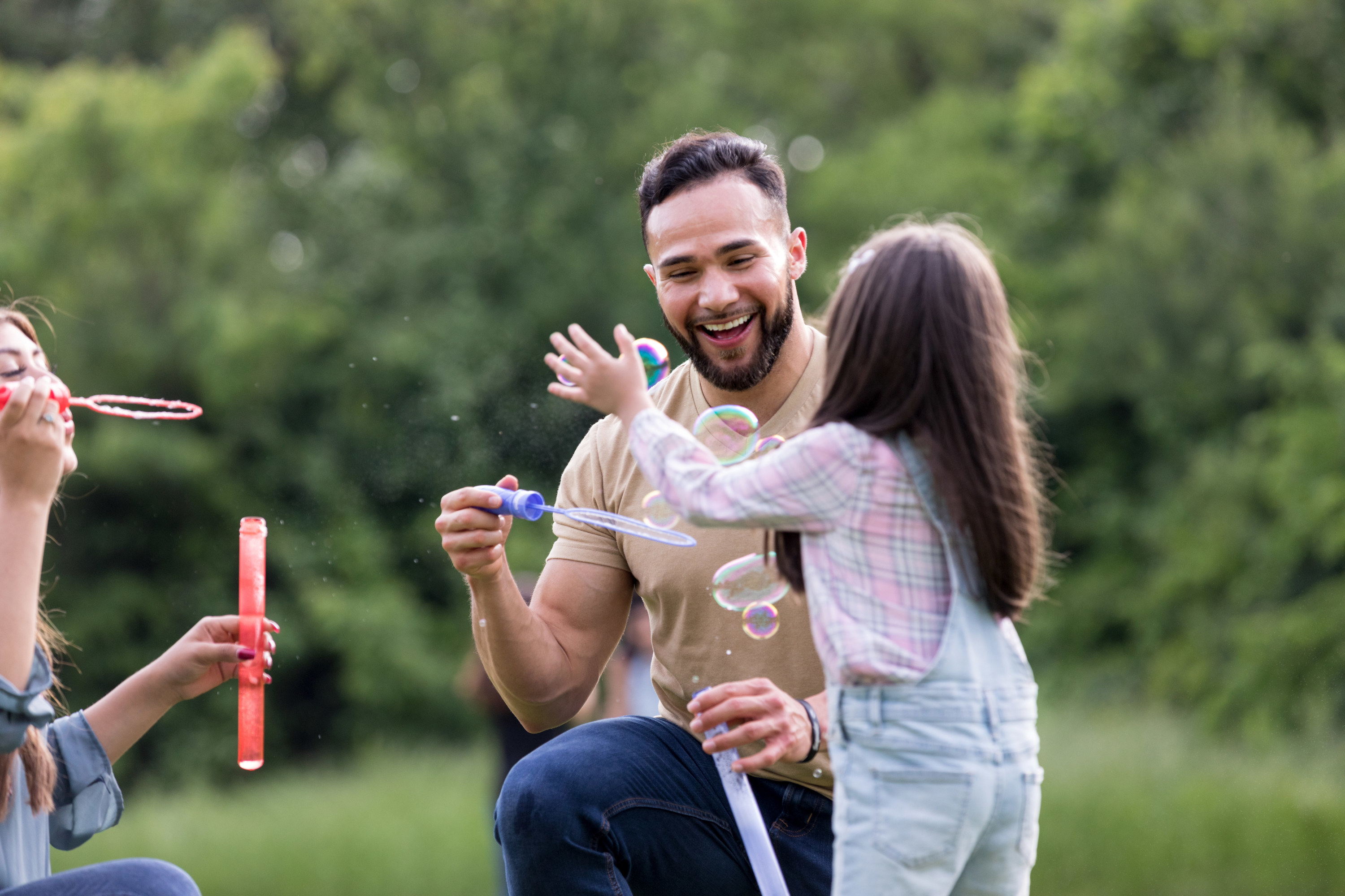 An uncle playing  bubbles with a niece