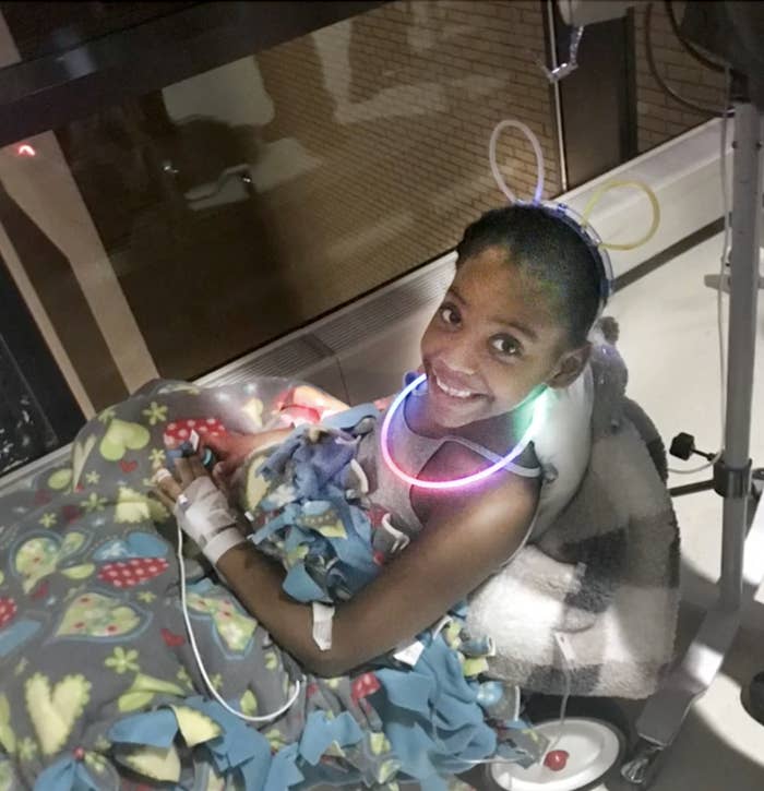 Chloe, wearing a glow necklace, receives treatment in the hospital