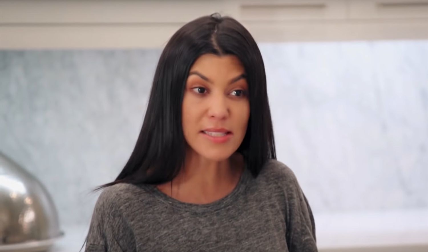 A closeup from the Kardashians of Kourtney looking defensive