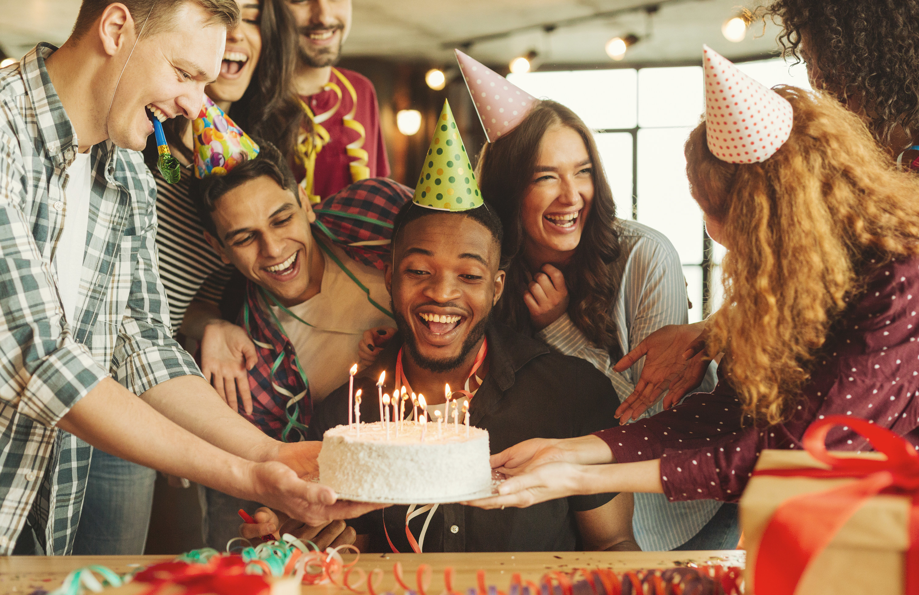 People having a birthday party and holding cake