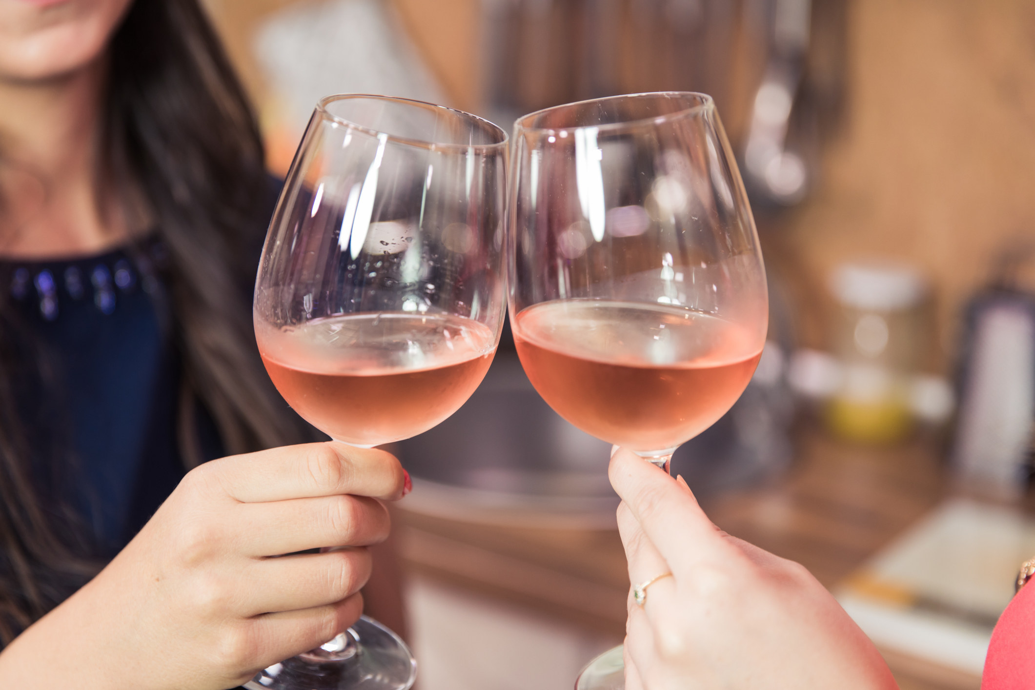 Two people clinking wine glasses full of rosé
