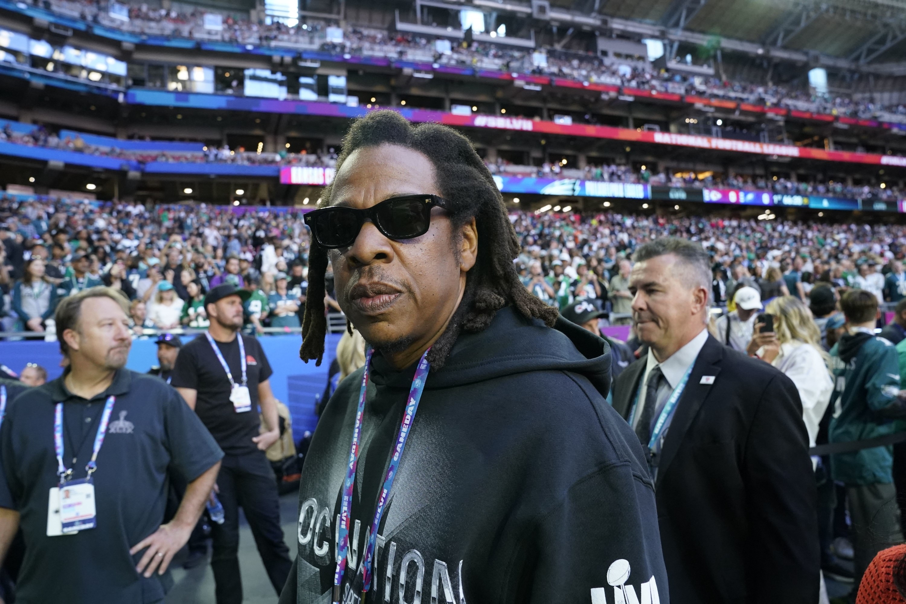 A close-up of Jay wearing sunglasses as he walks on the sideline at the Super Bowl