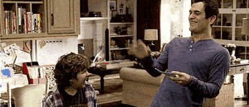 Phil Dunphy high-fiving his son in &quot;Modern Family&quot;