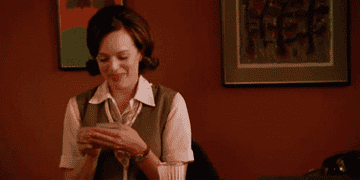 Peggy from &quot;Mad Men&quot; counting dollar bills and smiling
