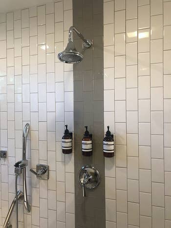 Reviewer's bottles are mounted to their shower wall