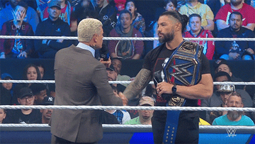Cody Rhodes and Roman Reigns exchange a tense handshake ahead of their championship match at Wrestlemania 39