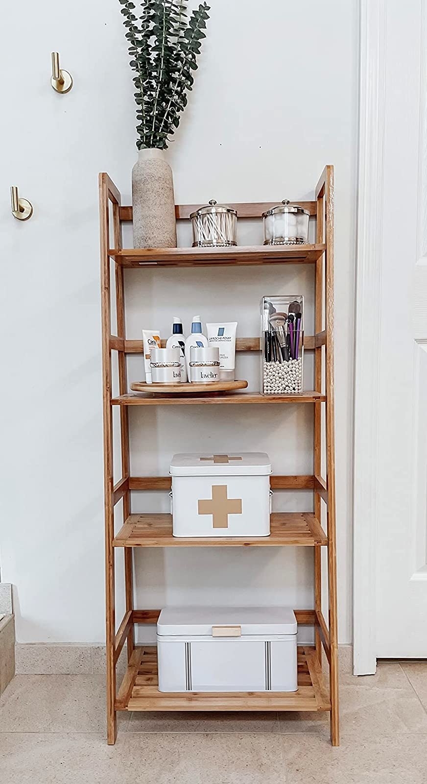 A bamboo shelf with various storage boxes and self-care products