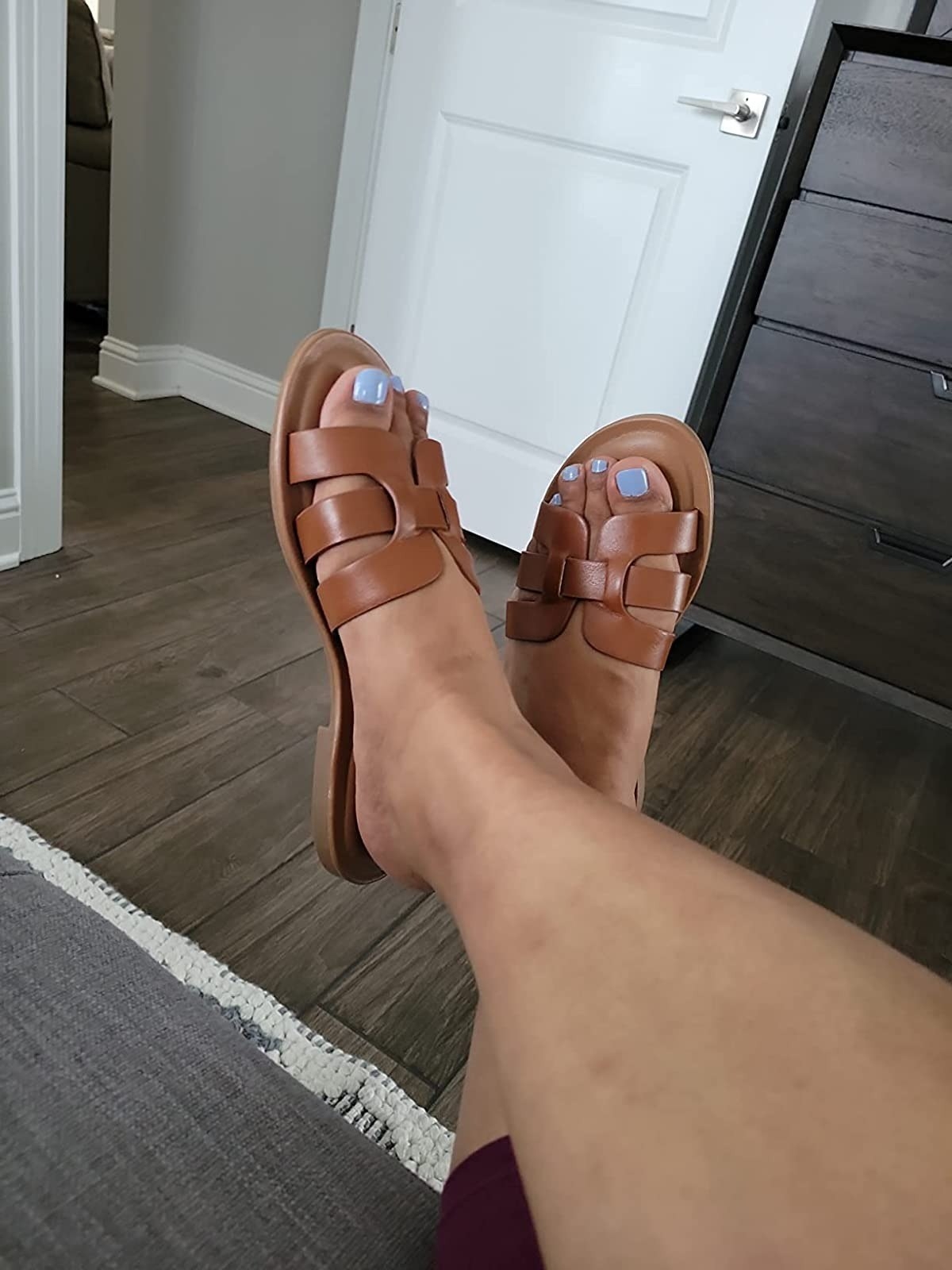 reviewer wearing the sandals with brown straps