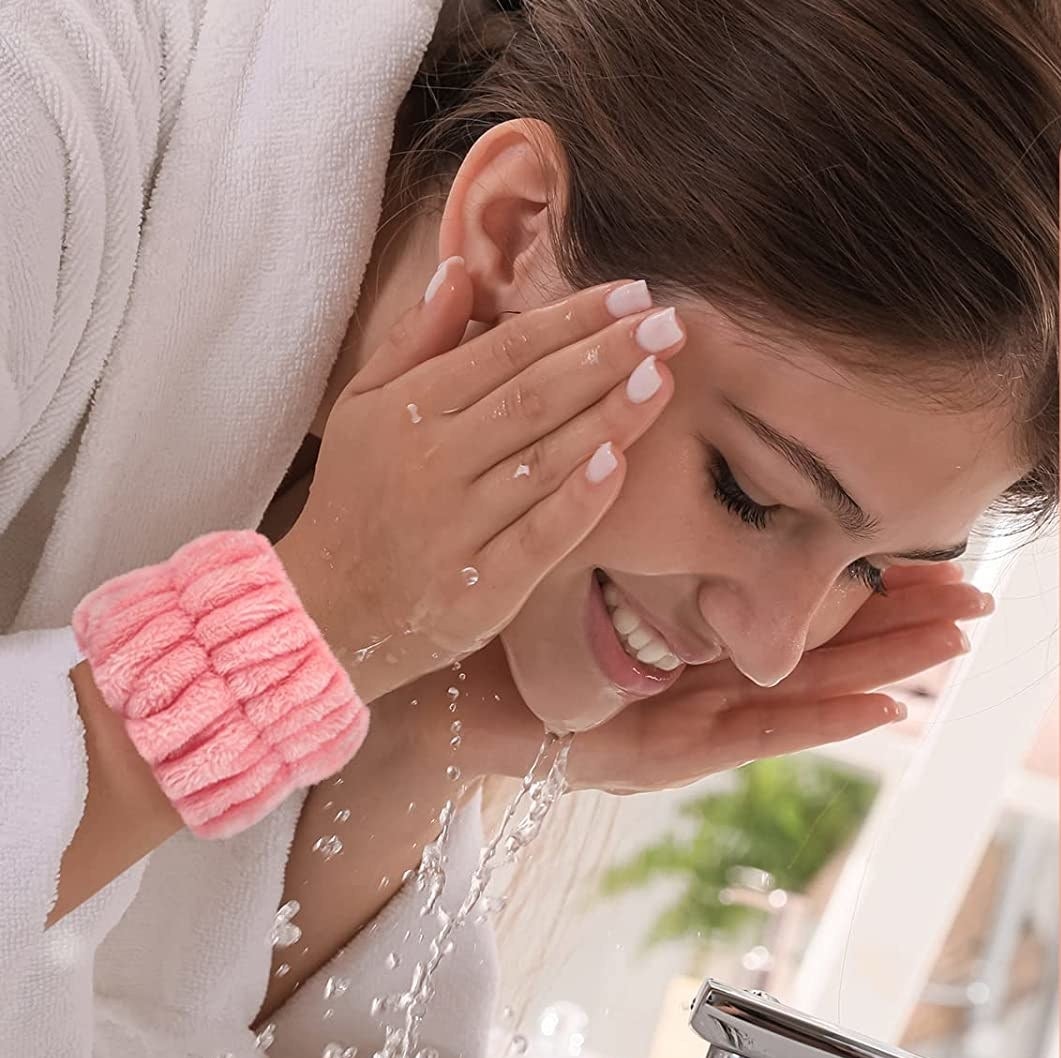 a person wearing the wristbands while washing their face over a sink
