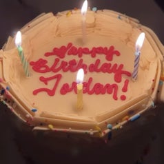 Another cake with vanilla frosting that says happy birthday jordan