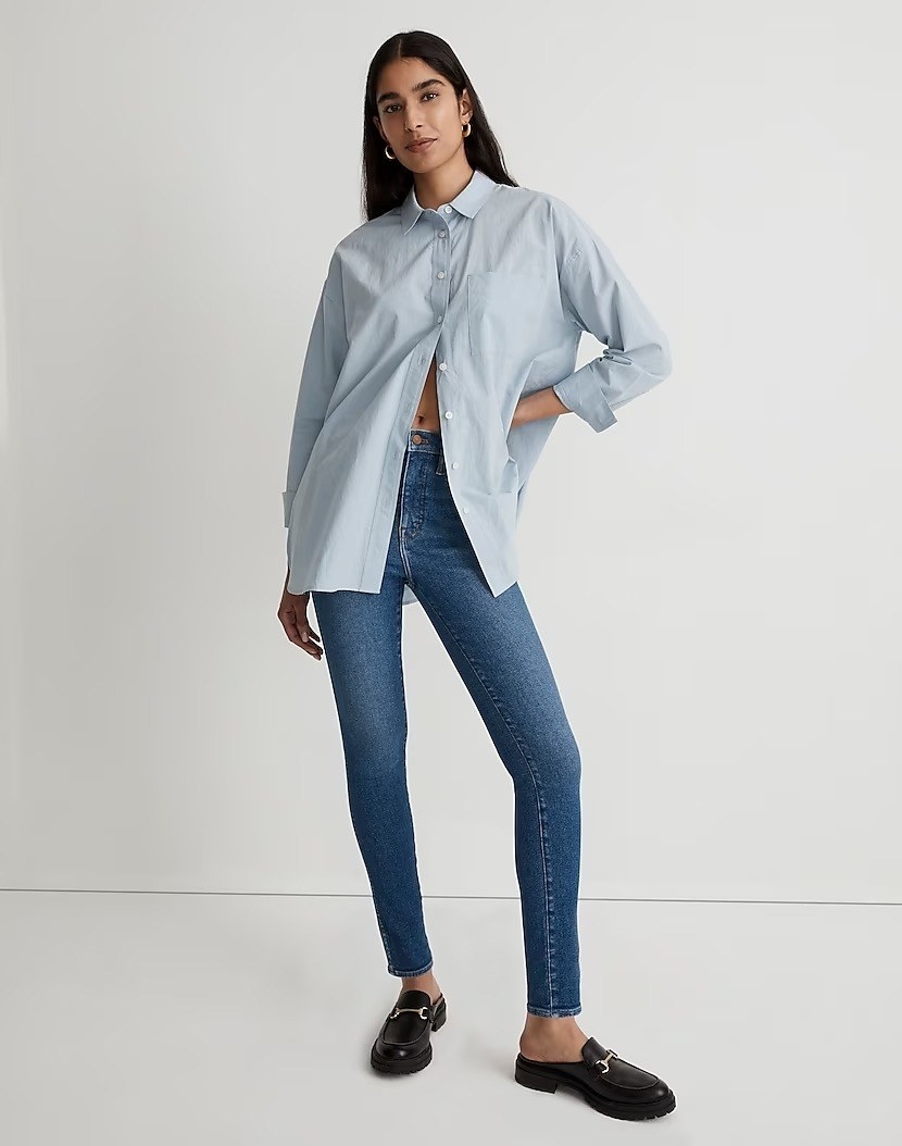 model wearing high-rise blue skinny jeans