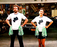 Jackie and Hyde performing a cheer with pompoms