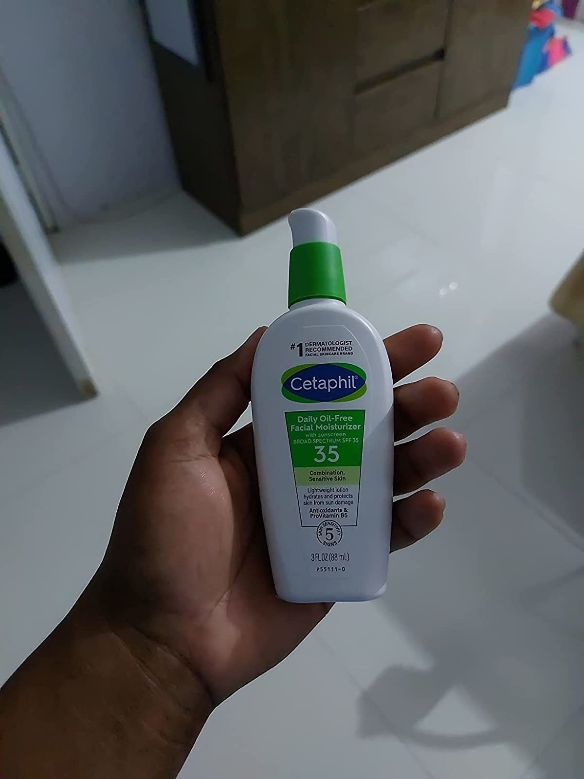 reviewer holding the Cetaphil moisturizer with SPF