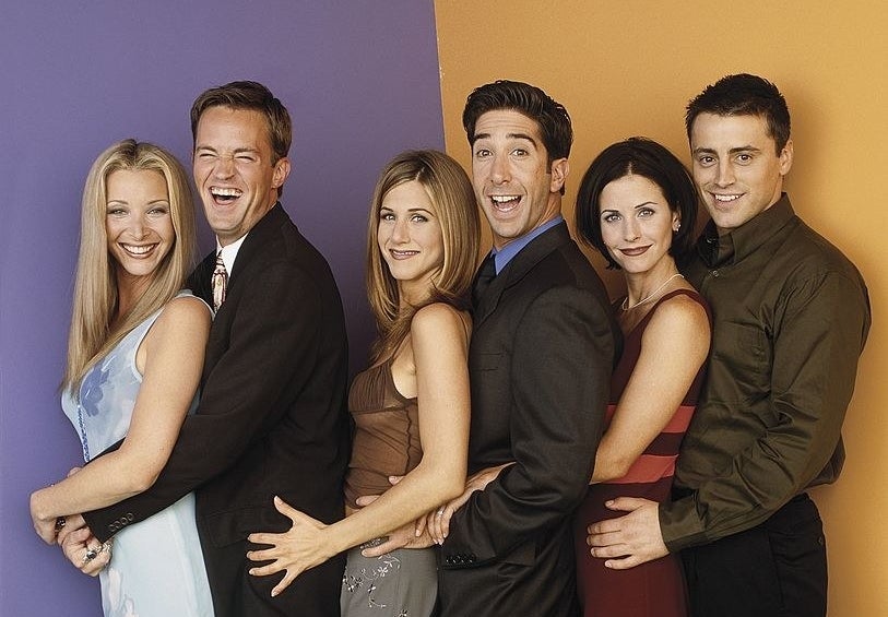 The cast of Friends smiling and embracing