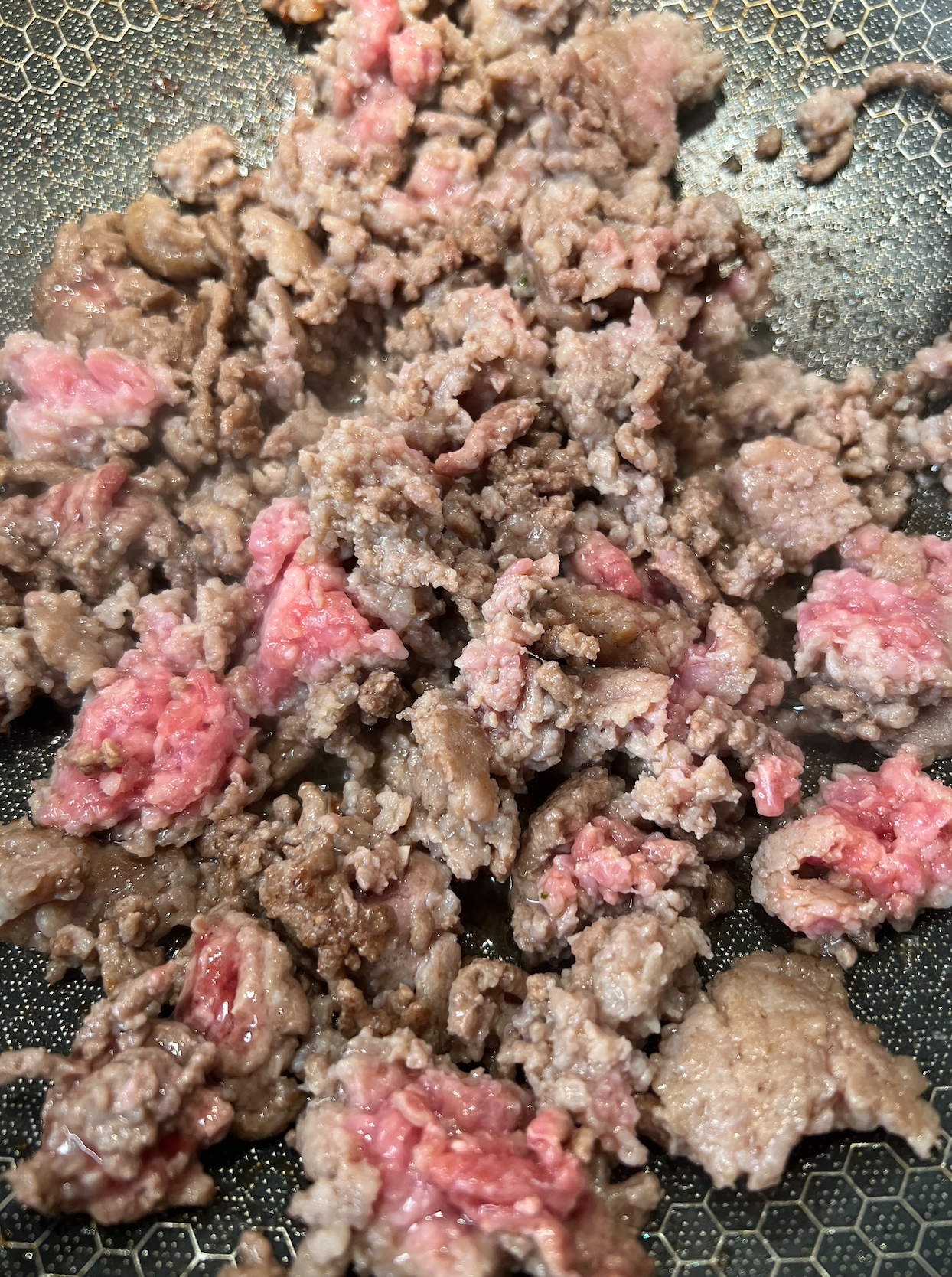 A closeup of the ground beef cooking