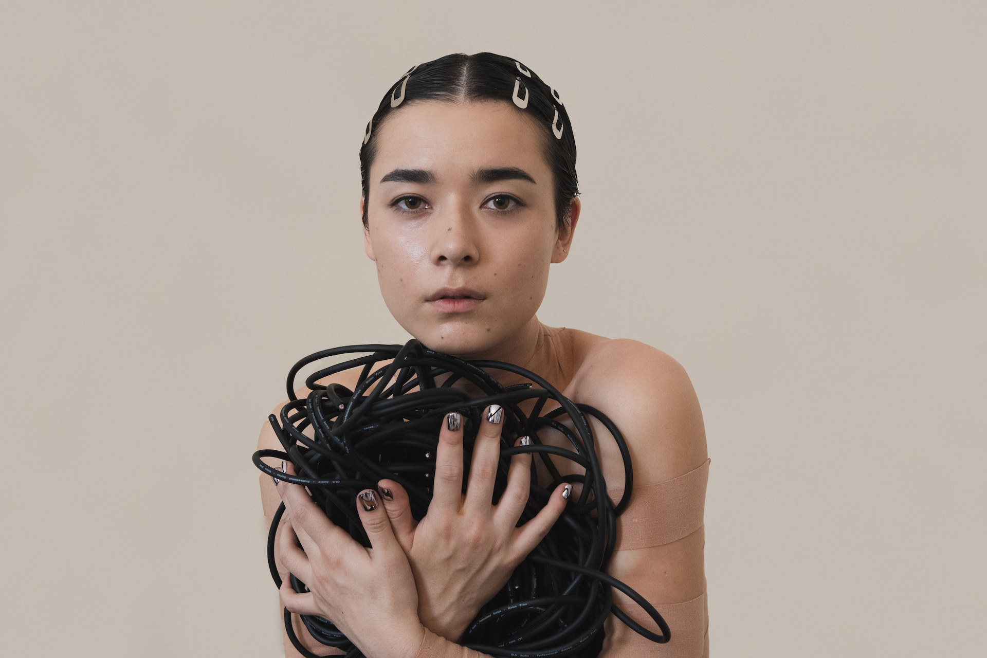 Miss Grit holding a bundle of black cable wires