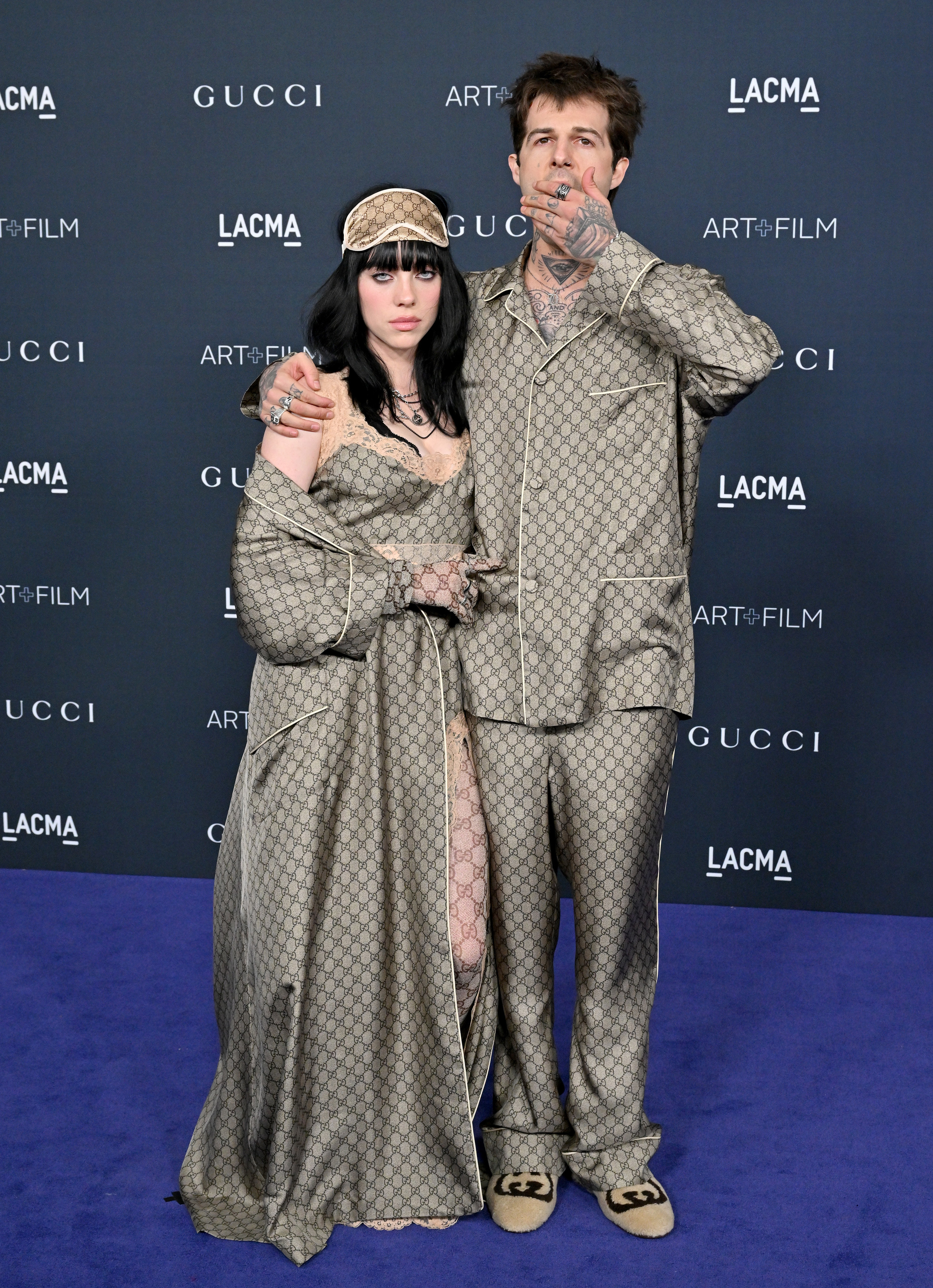 Jesse with his arm around Billie on the red carpet, both wearing matching print outfits