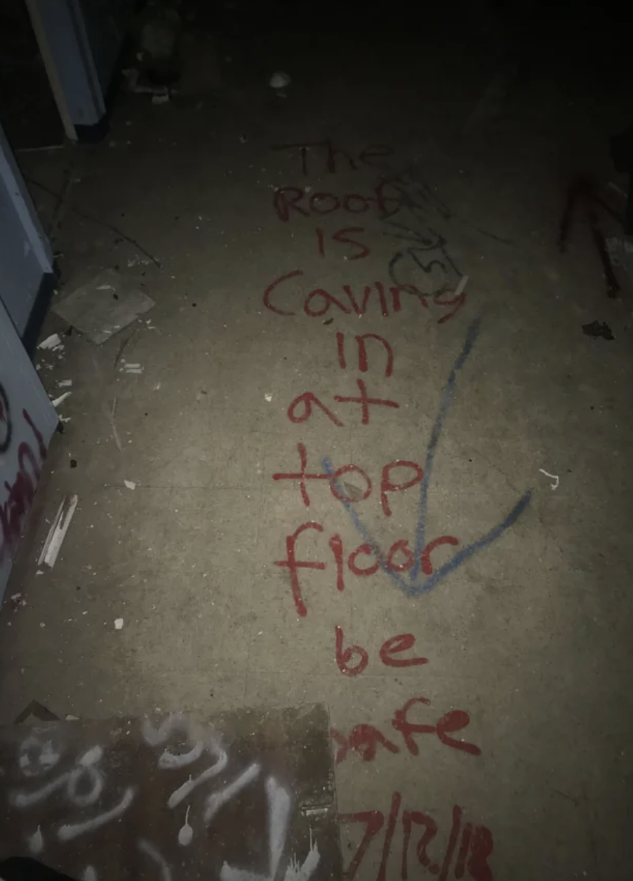 A message drawn on the floor says &quot;the roof is caving in at the top floor, be safe&quot;