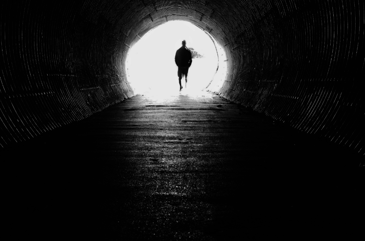 Man standing  at the end of a tunnel