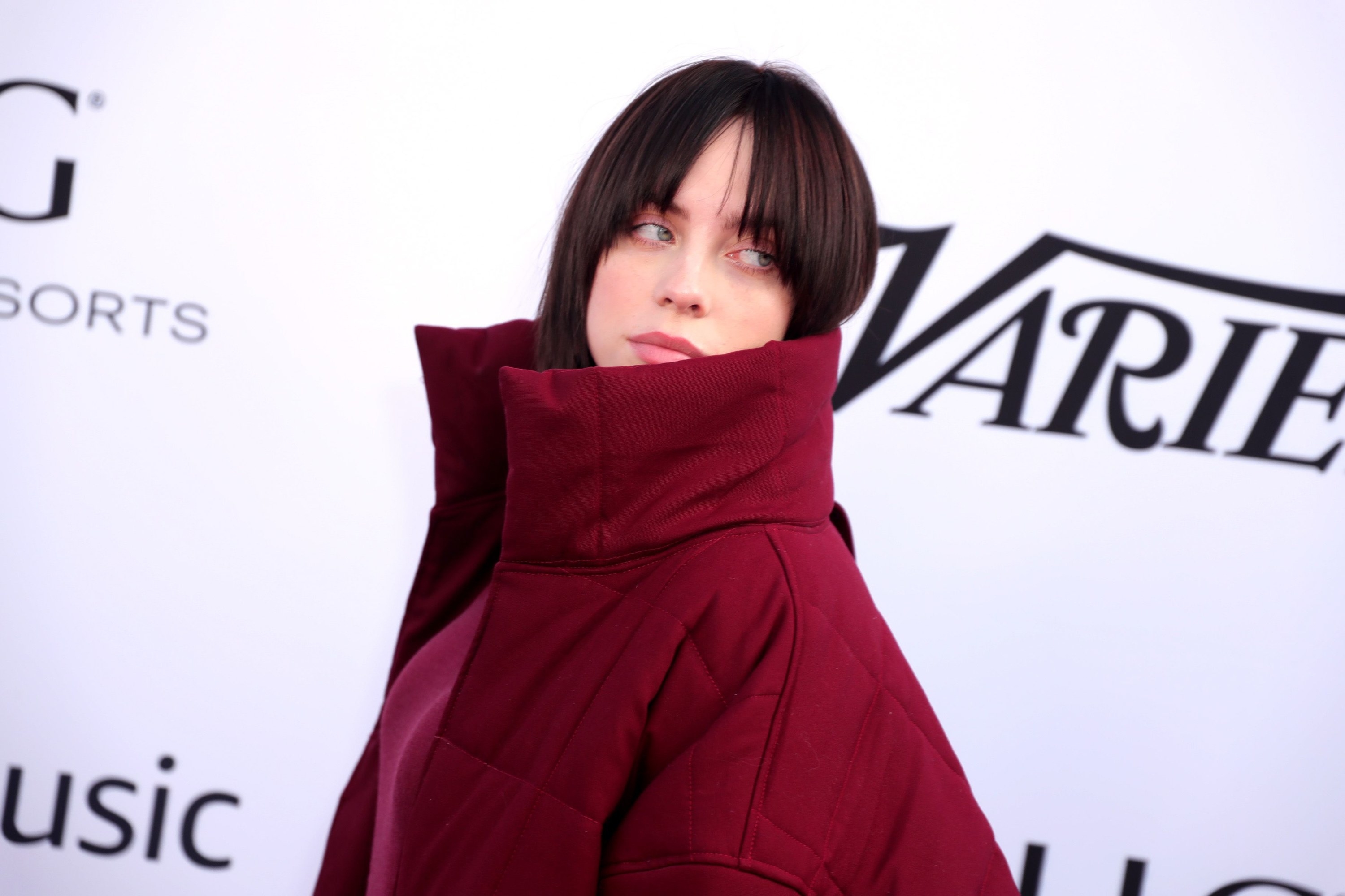 Close-up of Billie in a puffy coat at a red carpet event