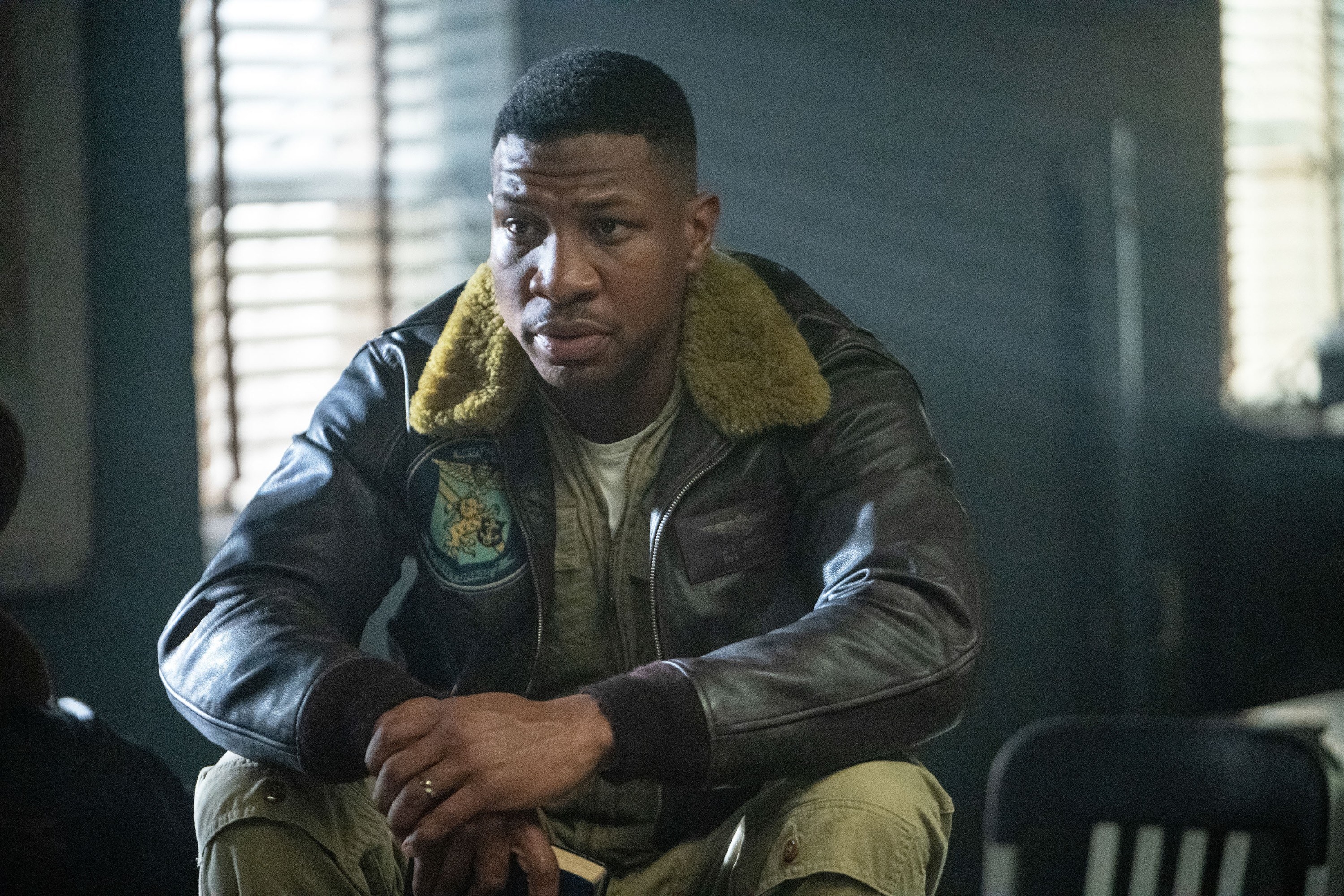 Major&#x27;s character sitting in a leather jacket