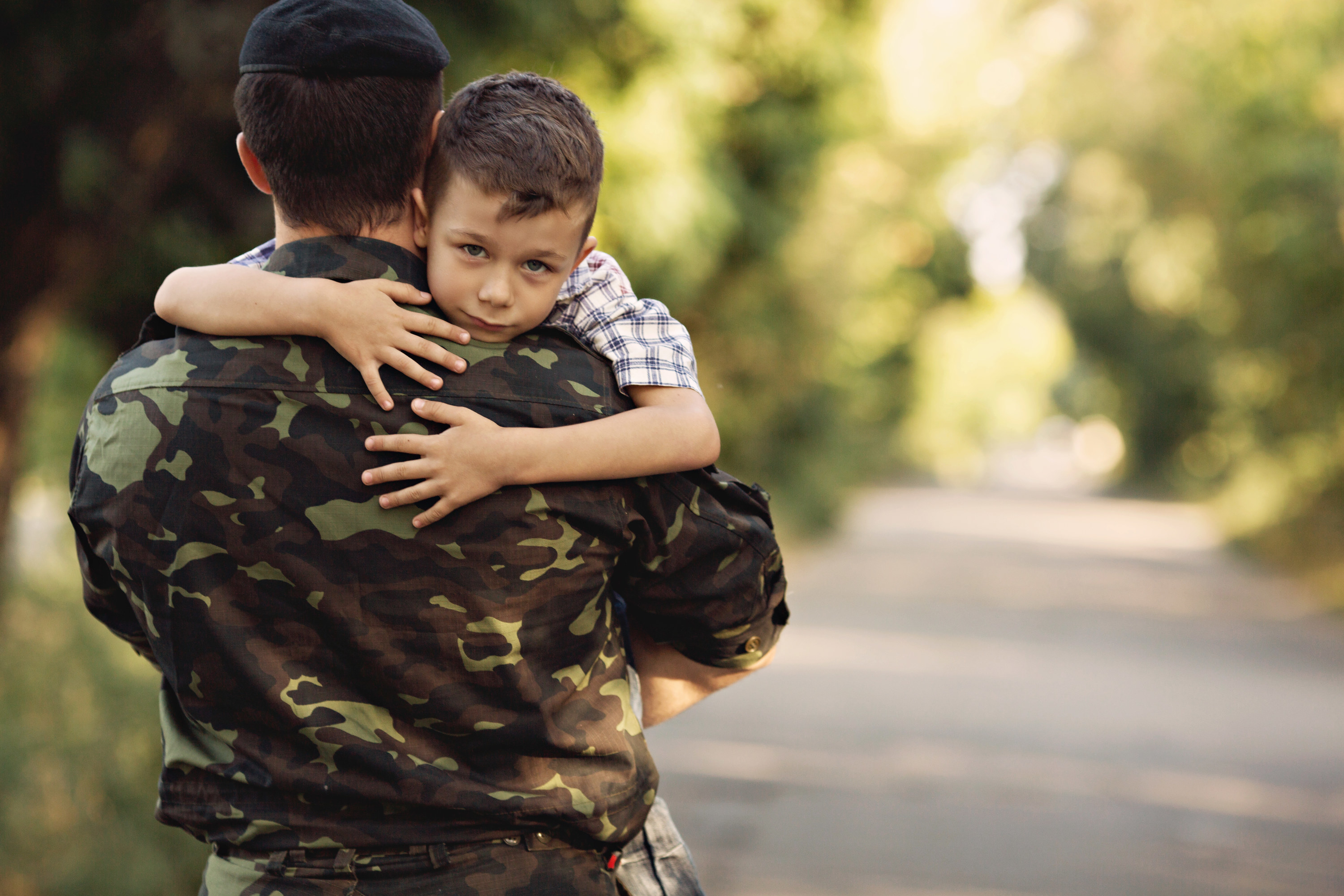 Little boy and soldier in a military uniform say goodbye before a separation