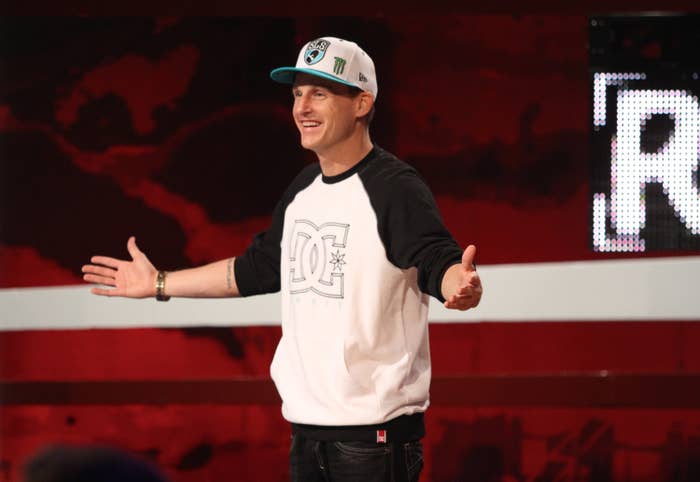 The host of Ridiculousness  smiles as he addresses the audience during an episodeof the show. He&#x27;s wearing a long-sleeved shirt, baseball cap, and jeans