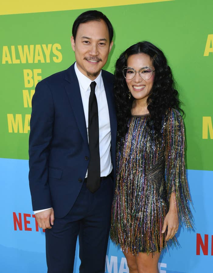 Ali Wong and Justin Hakuta on the red carpet at the premiere of &quot;Always Be My Maybe&quot;. Justin is wearing a suit and tie and Ali is wearing a multi-colored fringe dress that hits above the knees