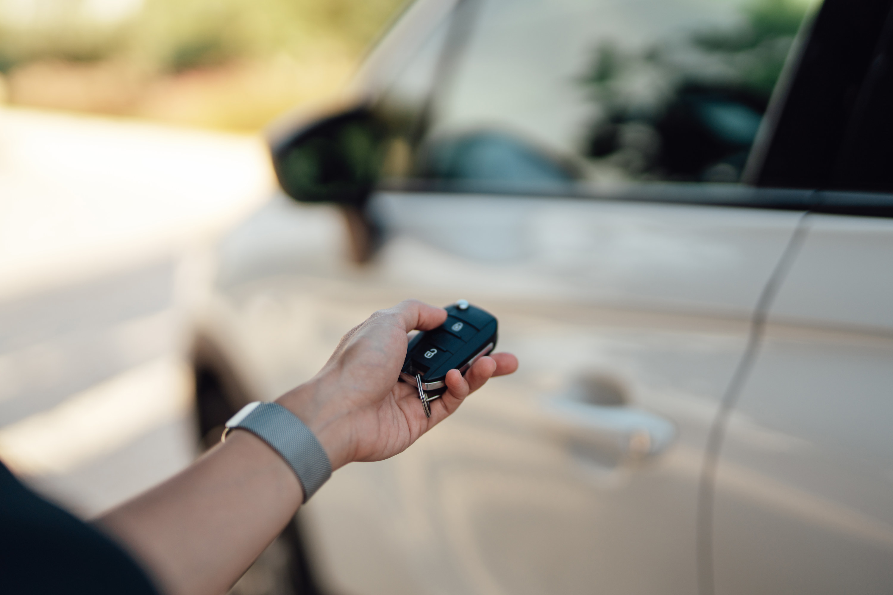 Close-up of female handing holding electronic car key to open care door