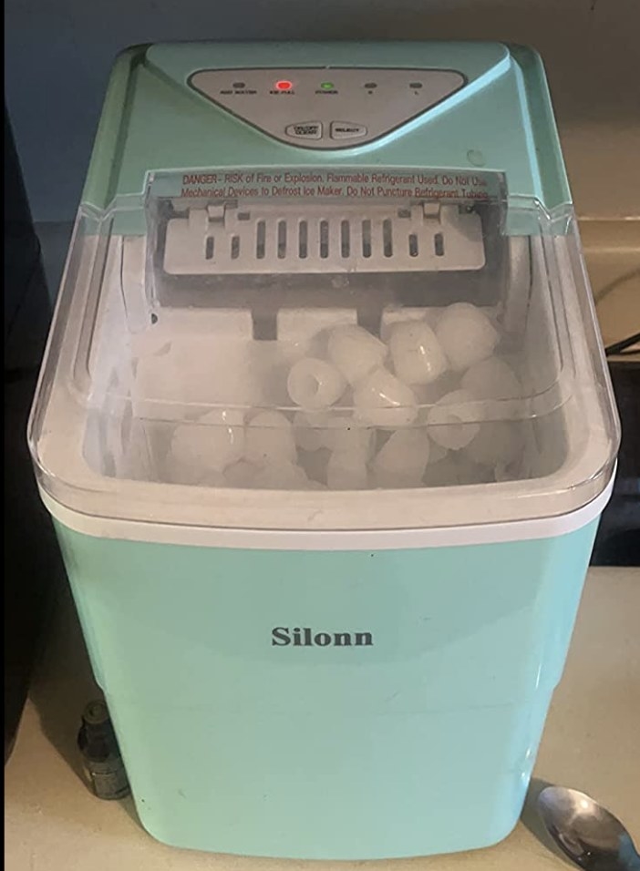 A reviewer&#x27;s light blue/green ice maker full of ice: &quot;nine cubes every six minutes&quot;