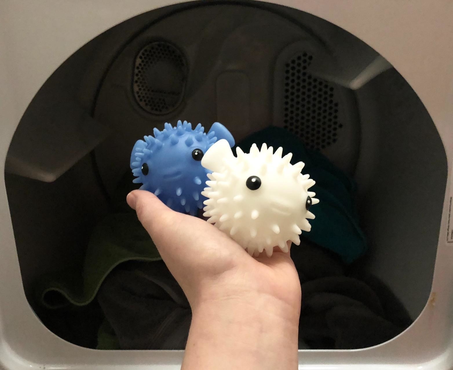 Reviewer holding the blue and white puffer balls in front of open dryer