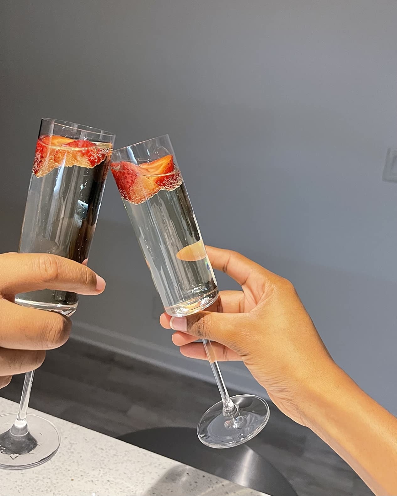 Two people clink reviewer&#x27;s champagne flutes