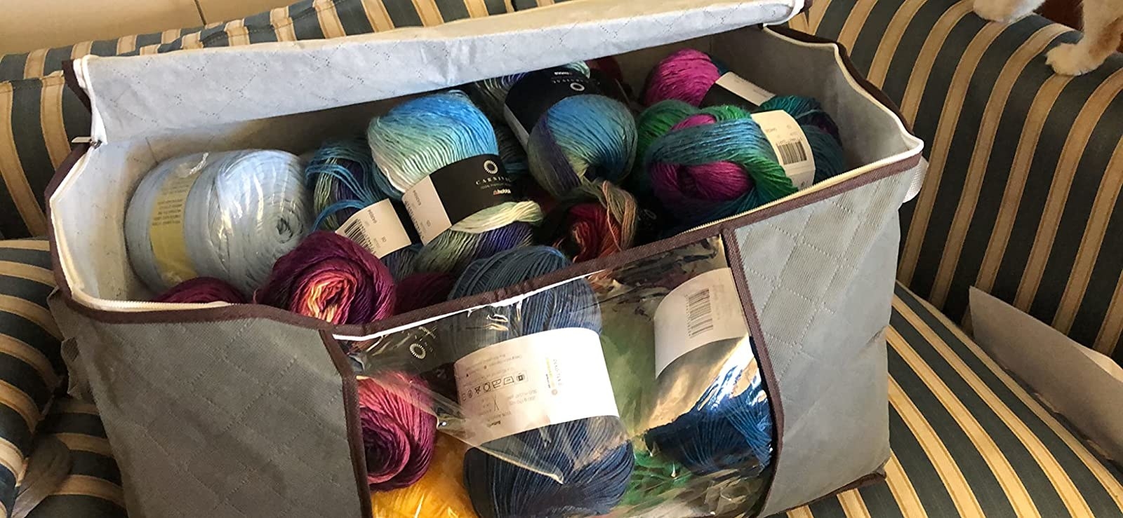 a reviewer photo of the grey bin filled with colorful balls of yarn
